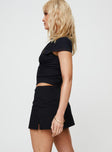 side view of model wearing Princess Polly Gigi Skort Black Lower Impact Low Rise Shorts