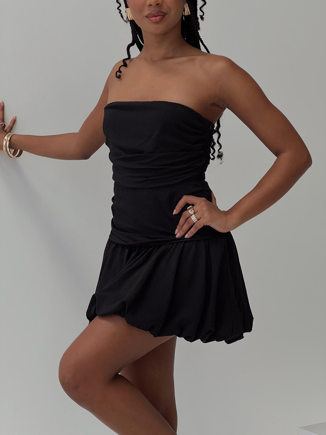 side view of model wearing Princess Polly Glamour Girl Strapless Bubble Hem Mini Dress Black Straight Neck 