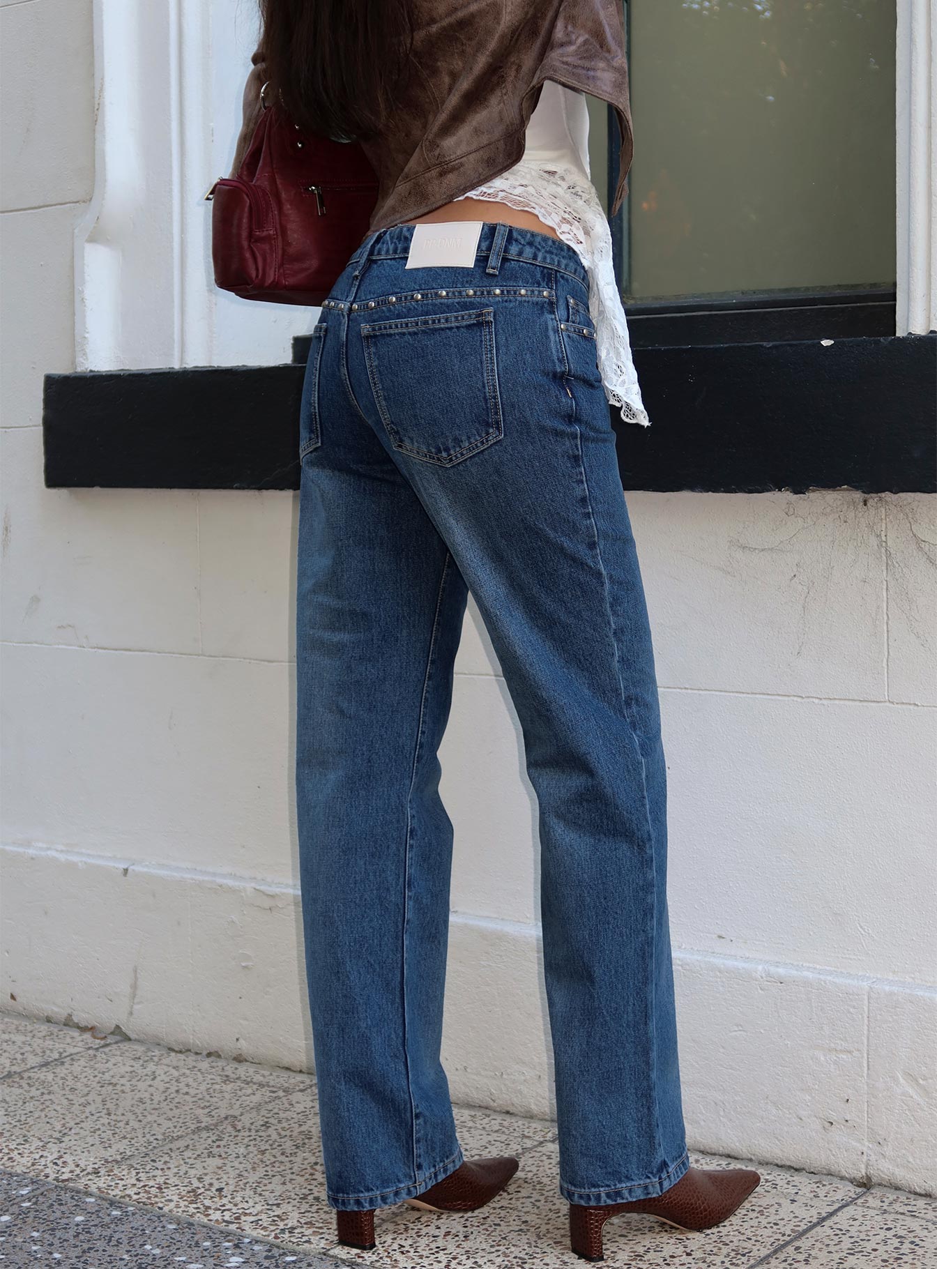 back view of model wearing Princess Polly So Dazzling Studded Low Rise Jeans Dark Wash Low Rise Jeans