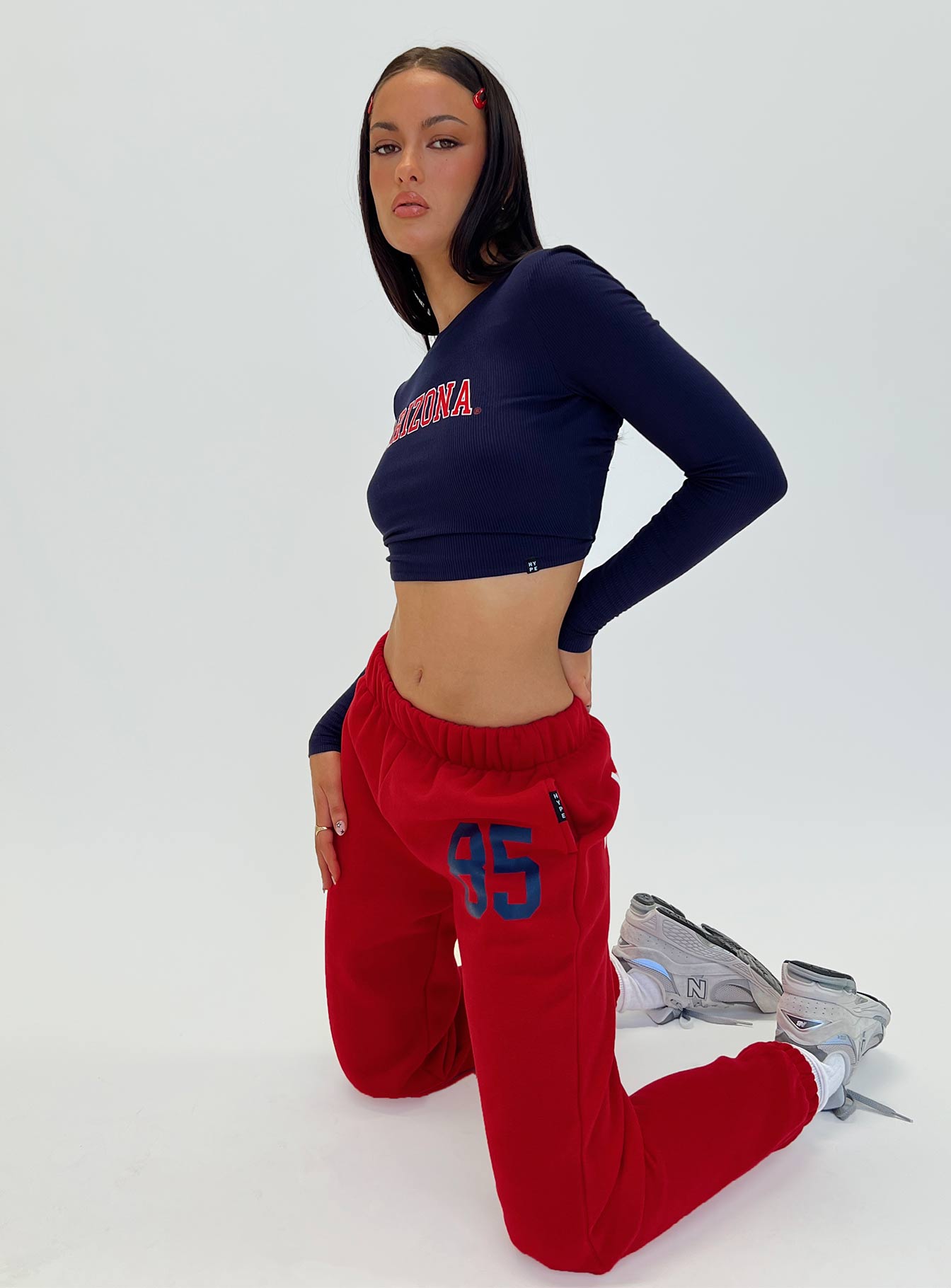 side view of model wearing Princess Polly U of A Sweatpants Red Low Rise Pants 