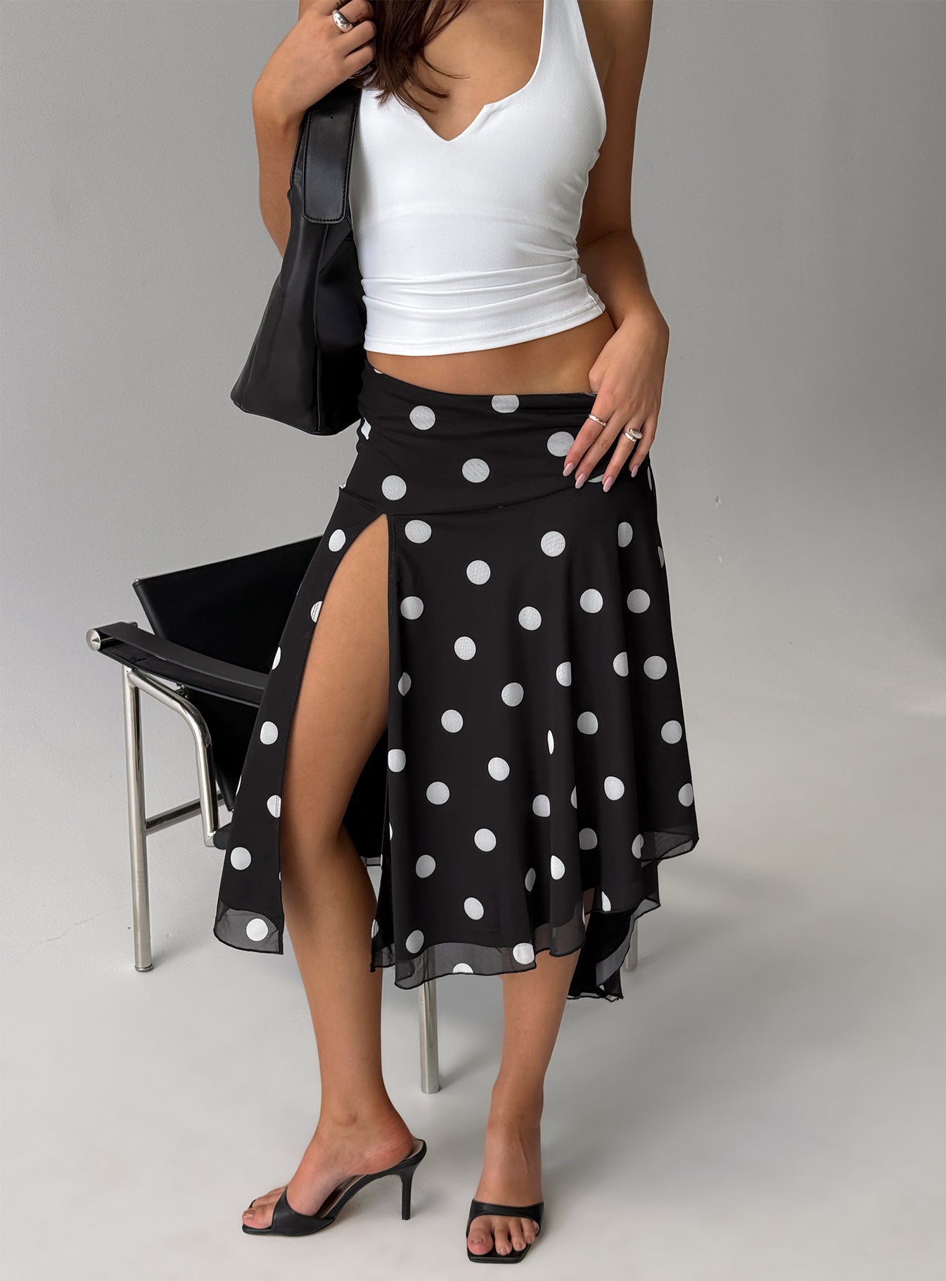   side view of model wearing Princess Polly Dulciana High Split Asymmetrical Midi Skirt Black / Polka Dot Midi Skirts 