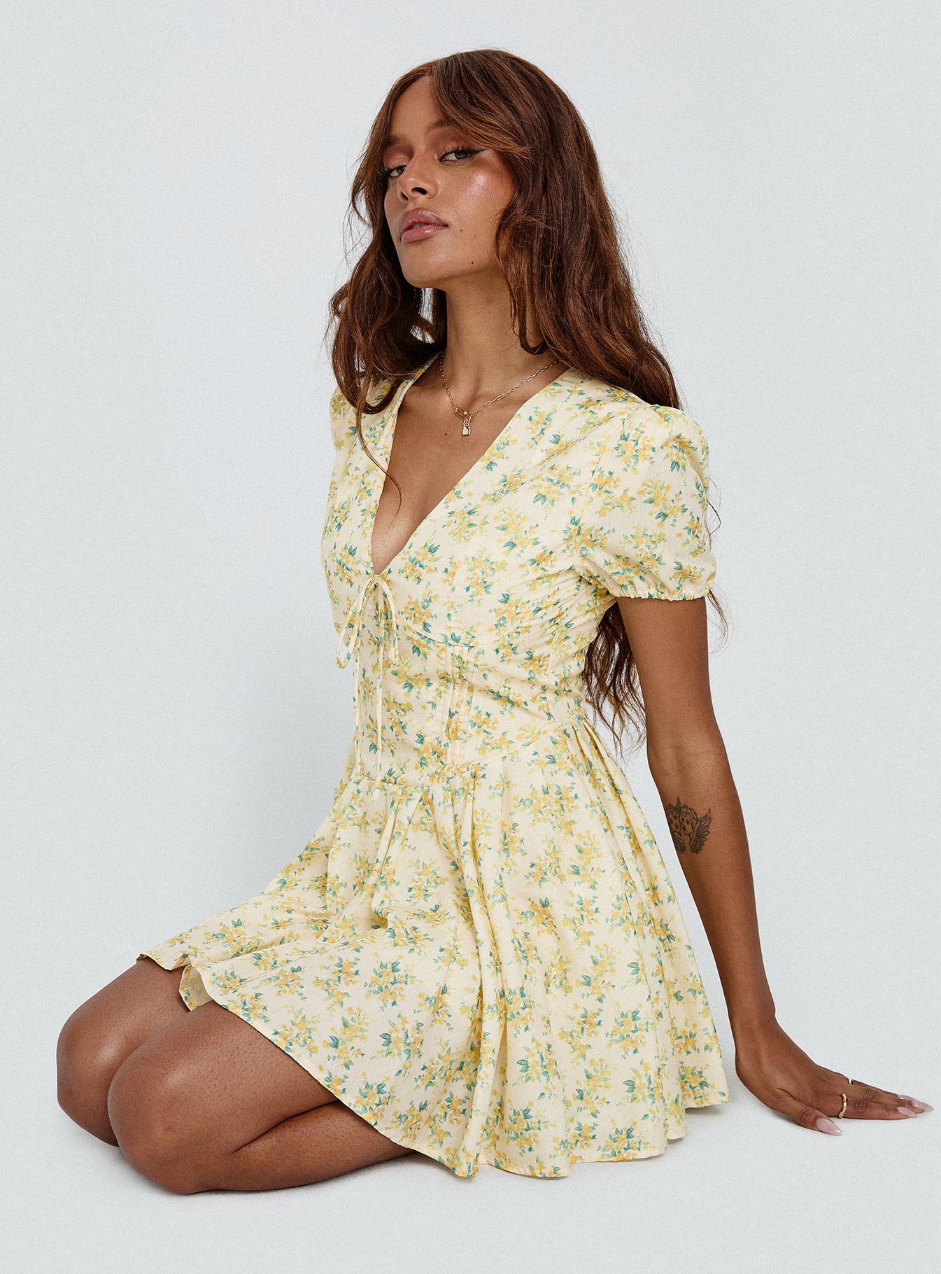 side view of model wearing Princess Polly Ethelyn Mini Dress Yellow Floral V-Neck 
