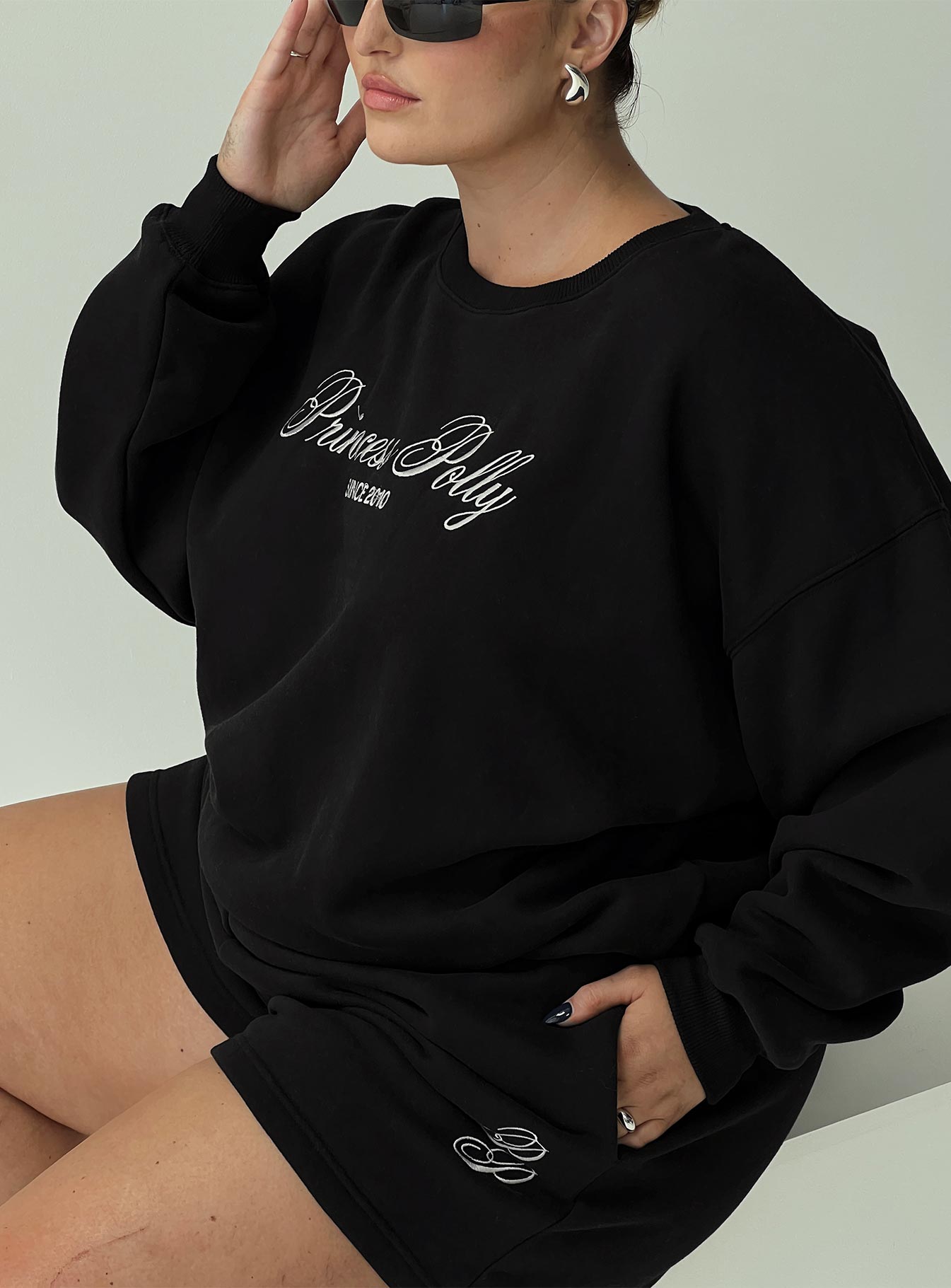 back view of model wearing Princess Polly Princess Polly Crew Neck Sweatshirt Cursive Text Black Sand Curve 