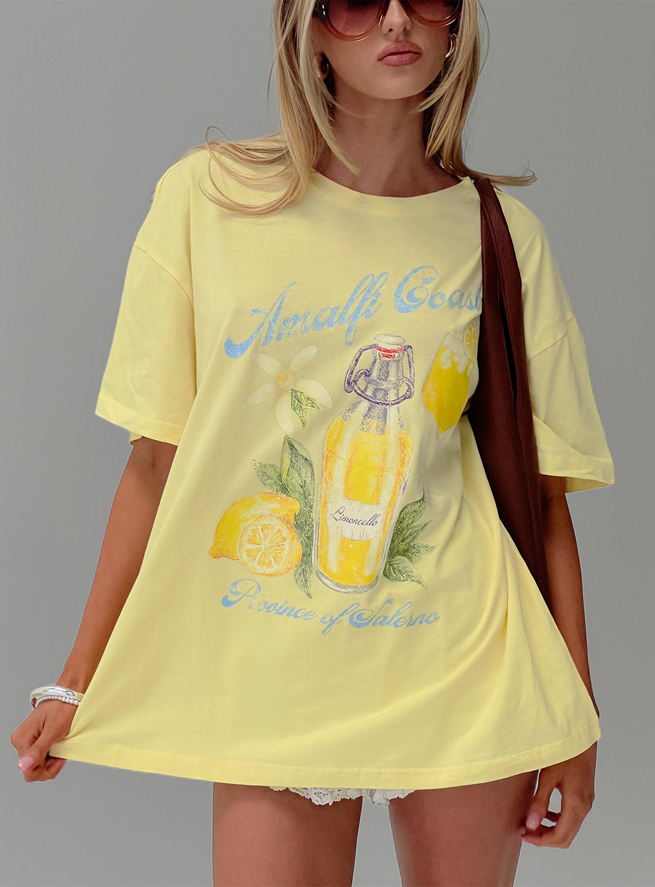 front view of model wearing Princess Polly Amalfi Coast Oversized Graphic Tee Pastel Yellow Half Sleeves Crew Neck 