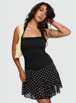   side view of model wearing Princess Polly Godet Mini Skirt Black / White Polka Mini Skirts 