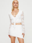 White Matching lace set Long sleeve top tie fastening at bust ruffle detail Mid rise mini skirt asymmetric hem