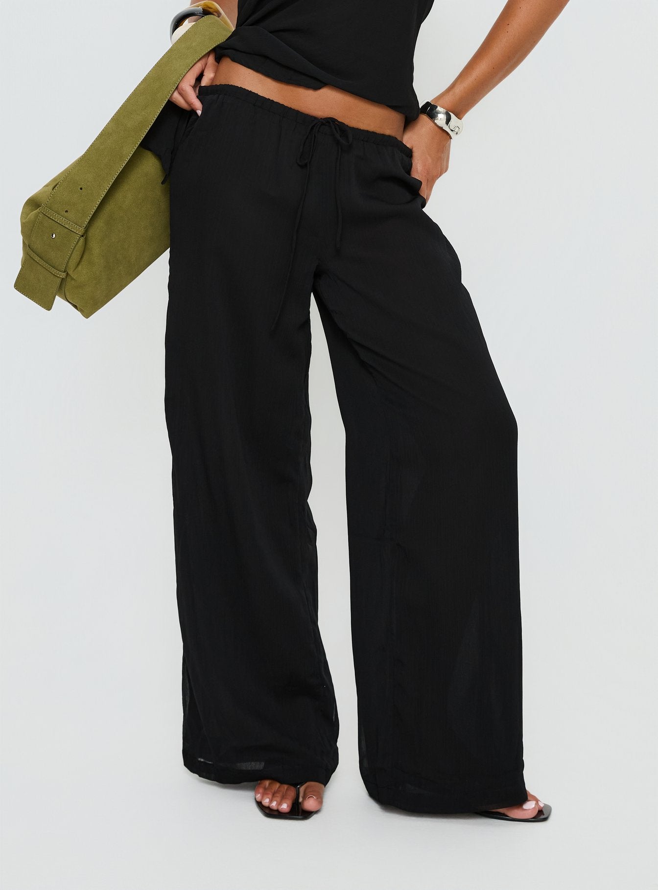 side view of model wearing Princess Polly Emorisa Mid Rise Chiffon Pant Black Mid Rise Pants 
