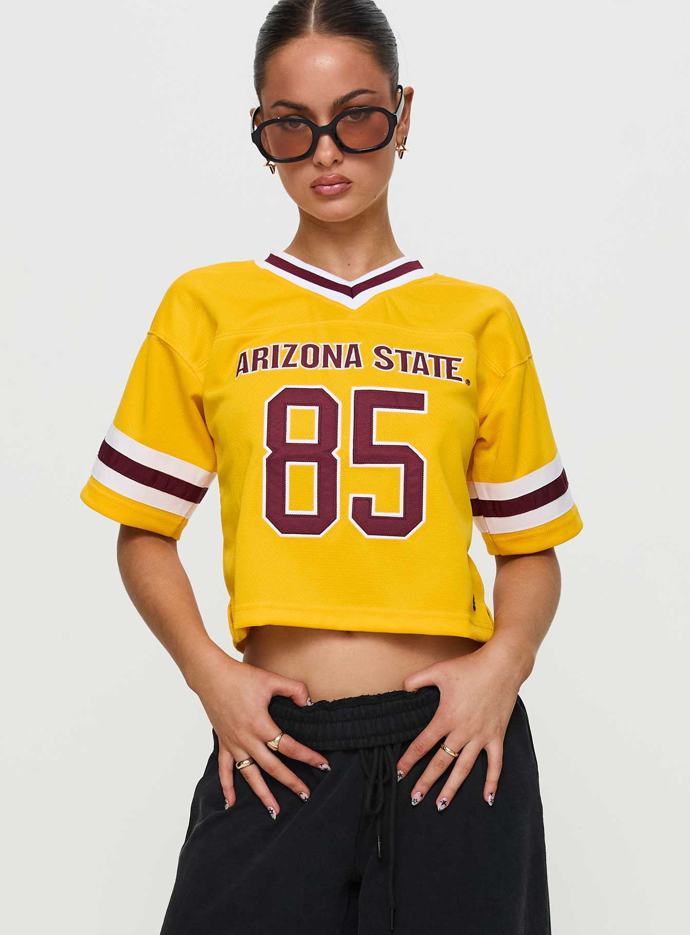 front view of model wearing Princess Polly ASU Football Jersey Gold Half Sleeves V-Neck 