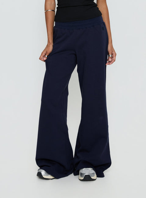 back view of model wearing Princess Polly Summits Flared Track Pants Navy Mid Rise Pants 