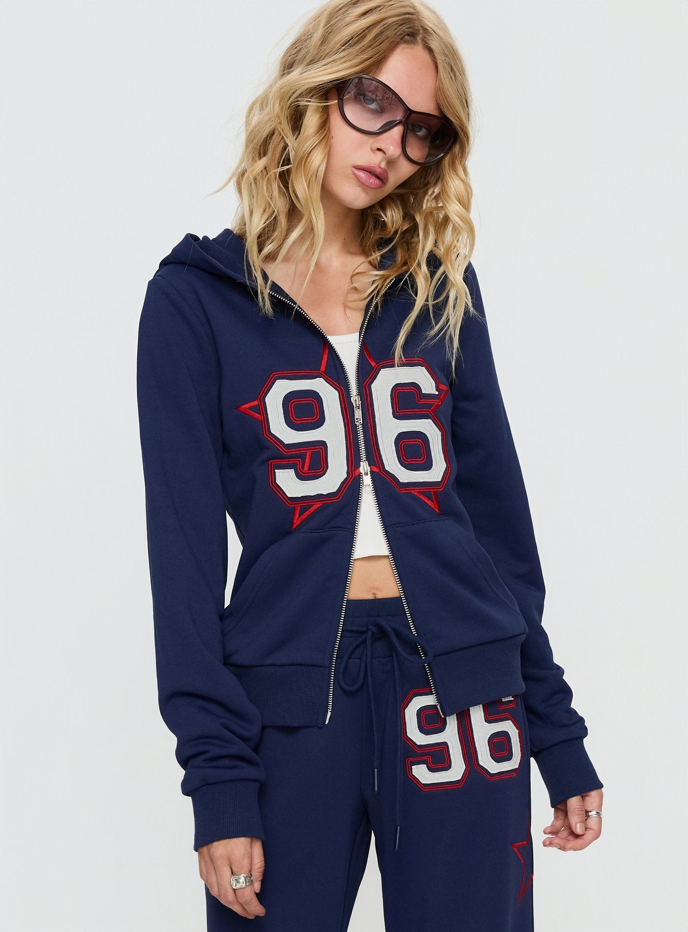 side view of model wearing Princess Polly Kari Distressed Zip Through Top Navy Multi Longline Jumpers 