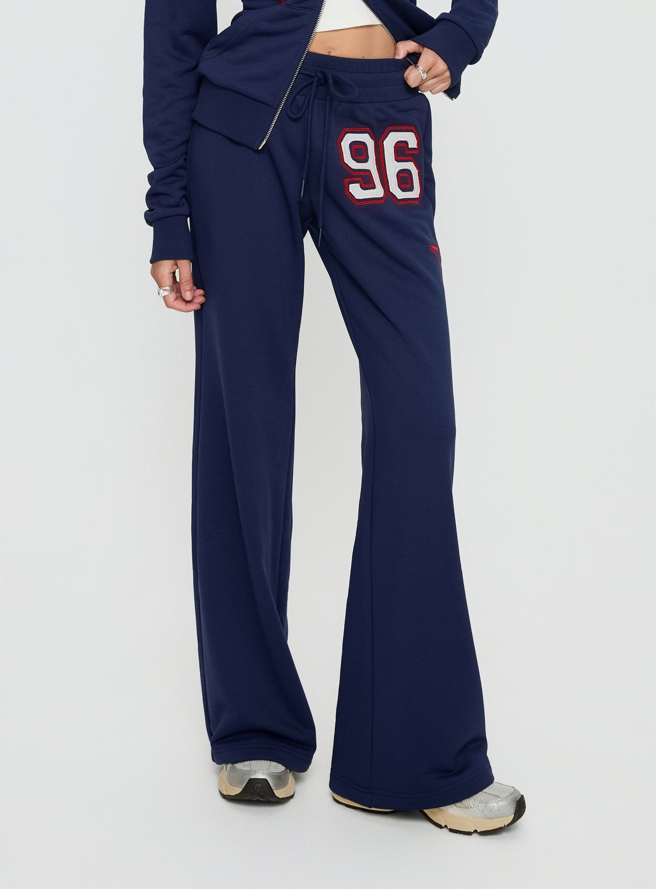 side view of model wearing Princess Polly Kari Distressed Patch Track Pant Navy Multi High Rise Pants 