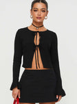 Top Long sleeves with ruffle cuff, sheer material, open front  Tie fastenings at front 