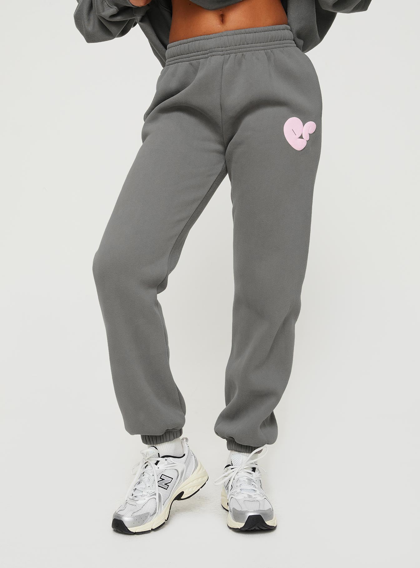 side view of model wearing Princess Polly Princess Polly Track Pants Bubble Text Charcoal / Light Pink Mid Rise 