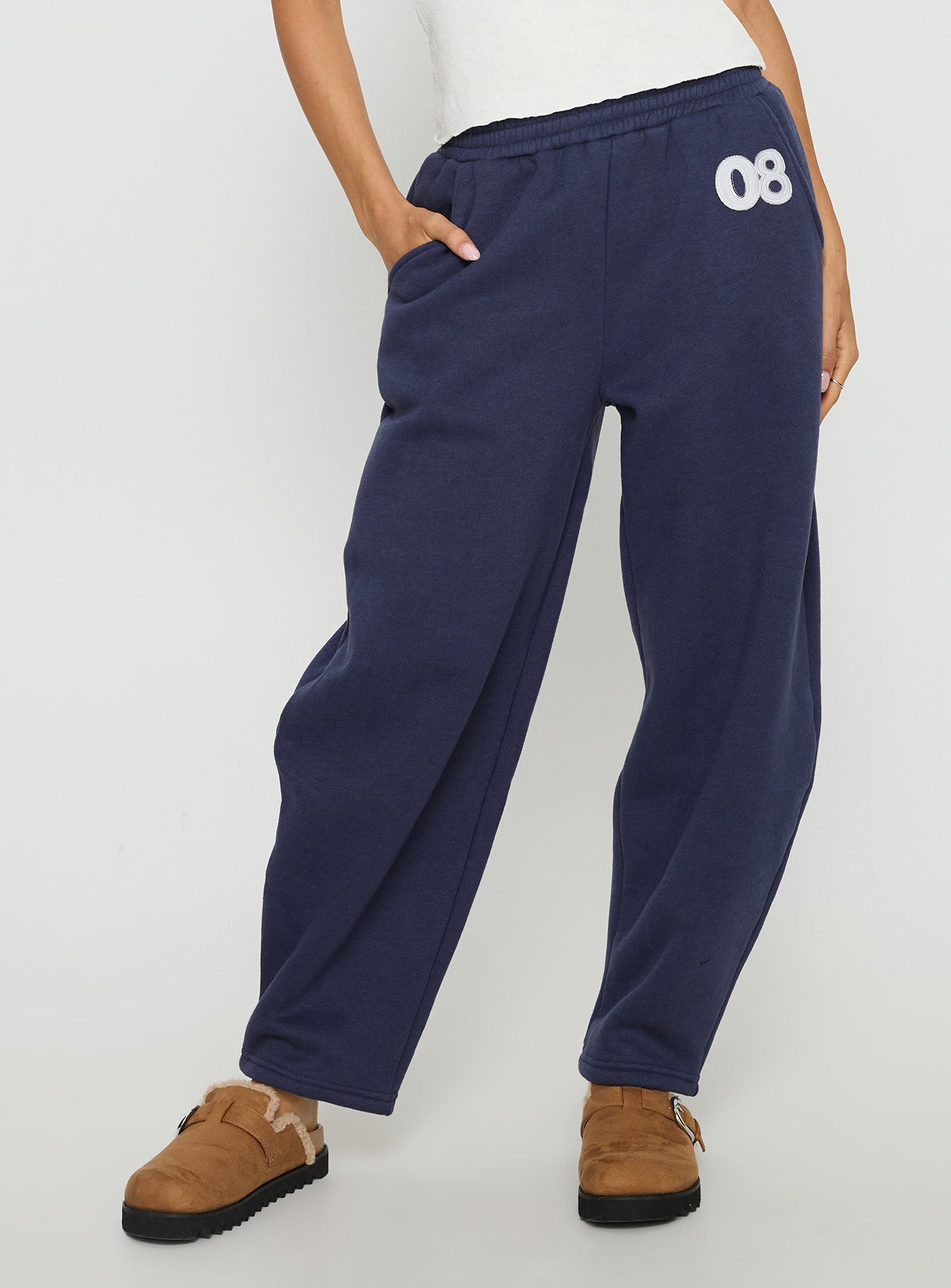 side view of model wearing Princess Polly Route 08 Barrel Track Pant Navy Mid Rise Pants 