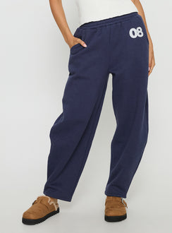 side view of model wearing Princess Polly Route 08 Barrel Track Pant Navy Mid Rise Pants 