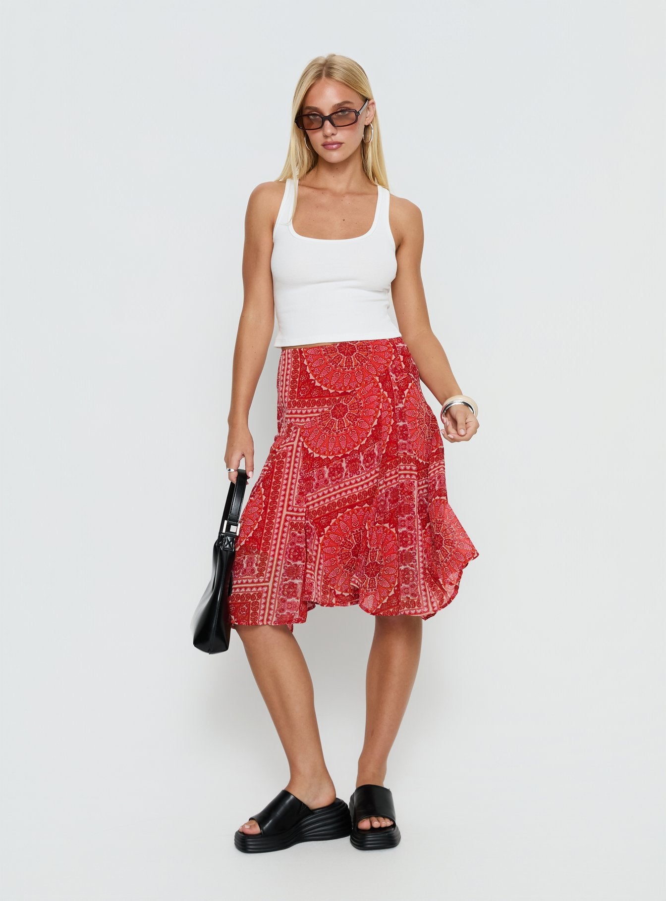   side view of model wearing Princess Polly Raenah Asymmetrical Midi Skirt Red Paisley 