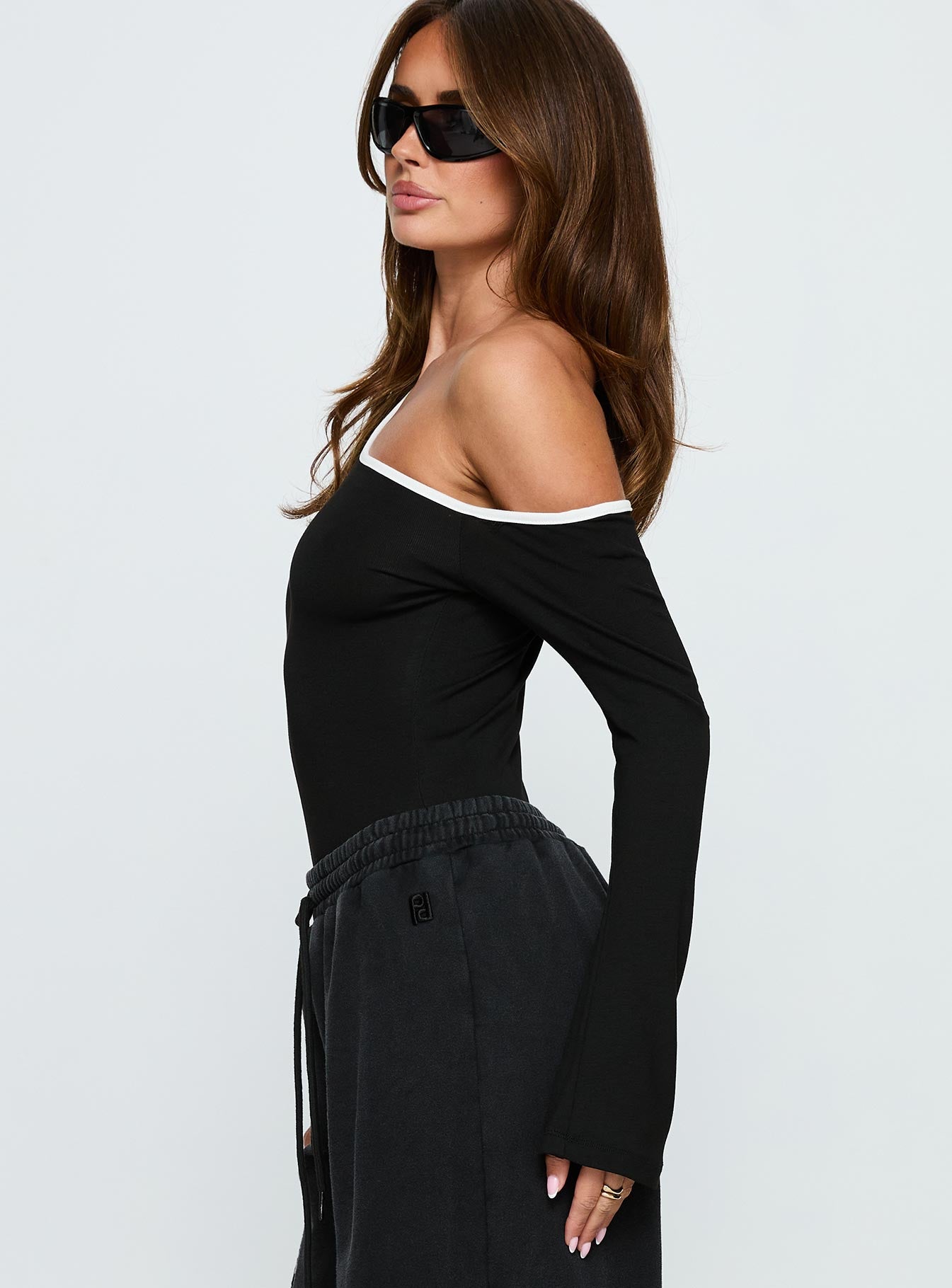 side view of model wearing Princess Polly Andrielle One Shoulder Long Sleeve Bodysuit Black / White Long Sleeve Tops 