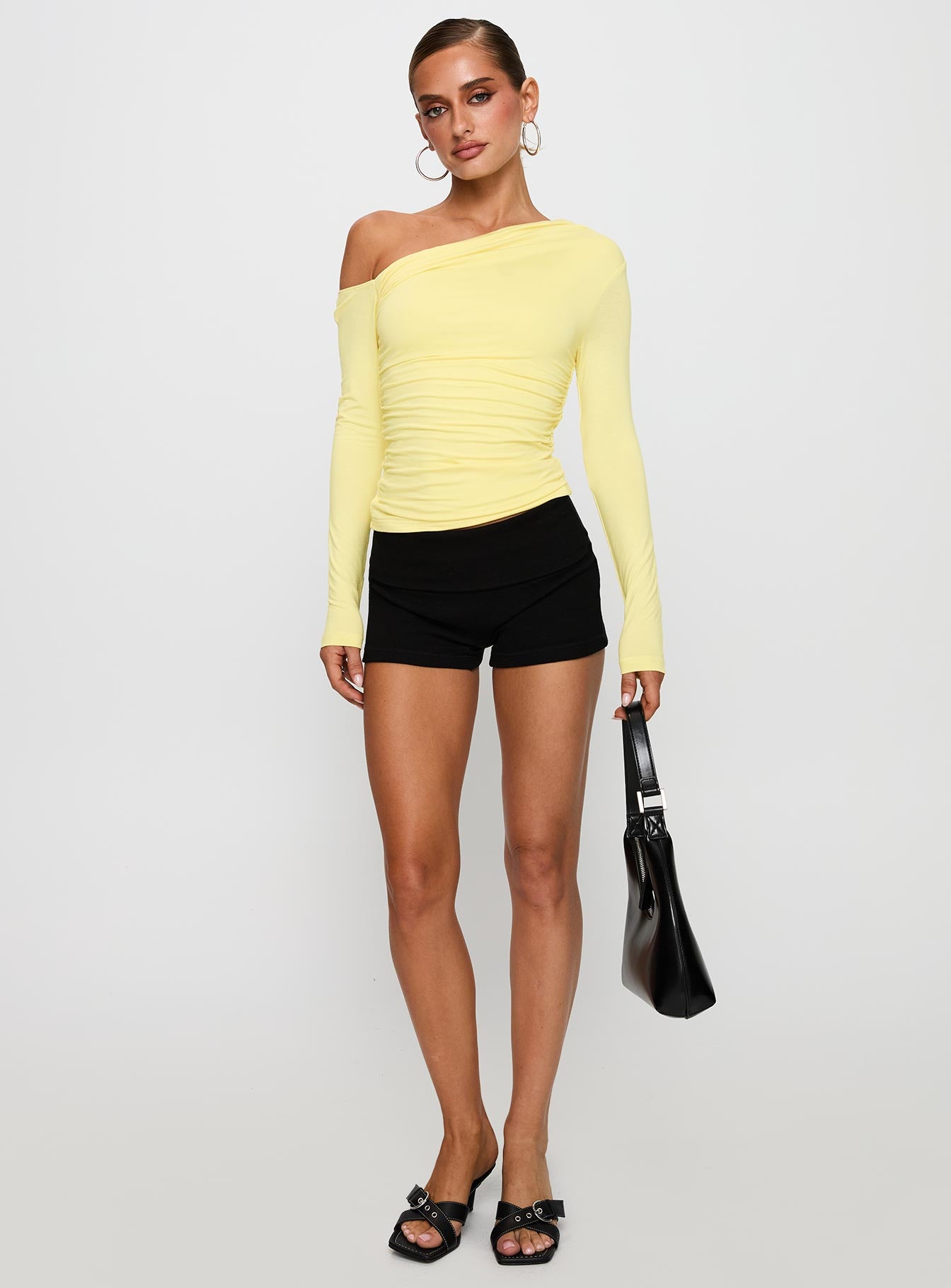 back view of model wearing Princess Polly Beller Long Sleeve Top Lemon Full Sleeves Asymmetric Neckline 