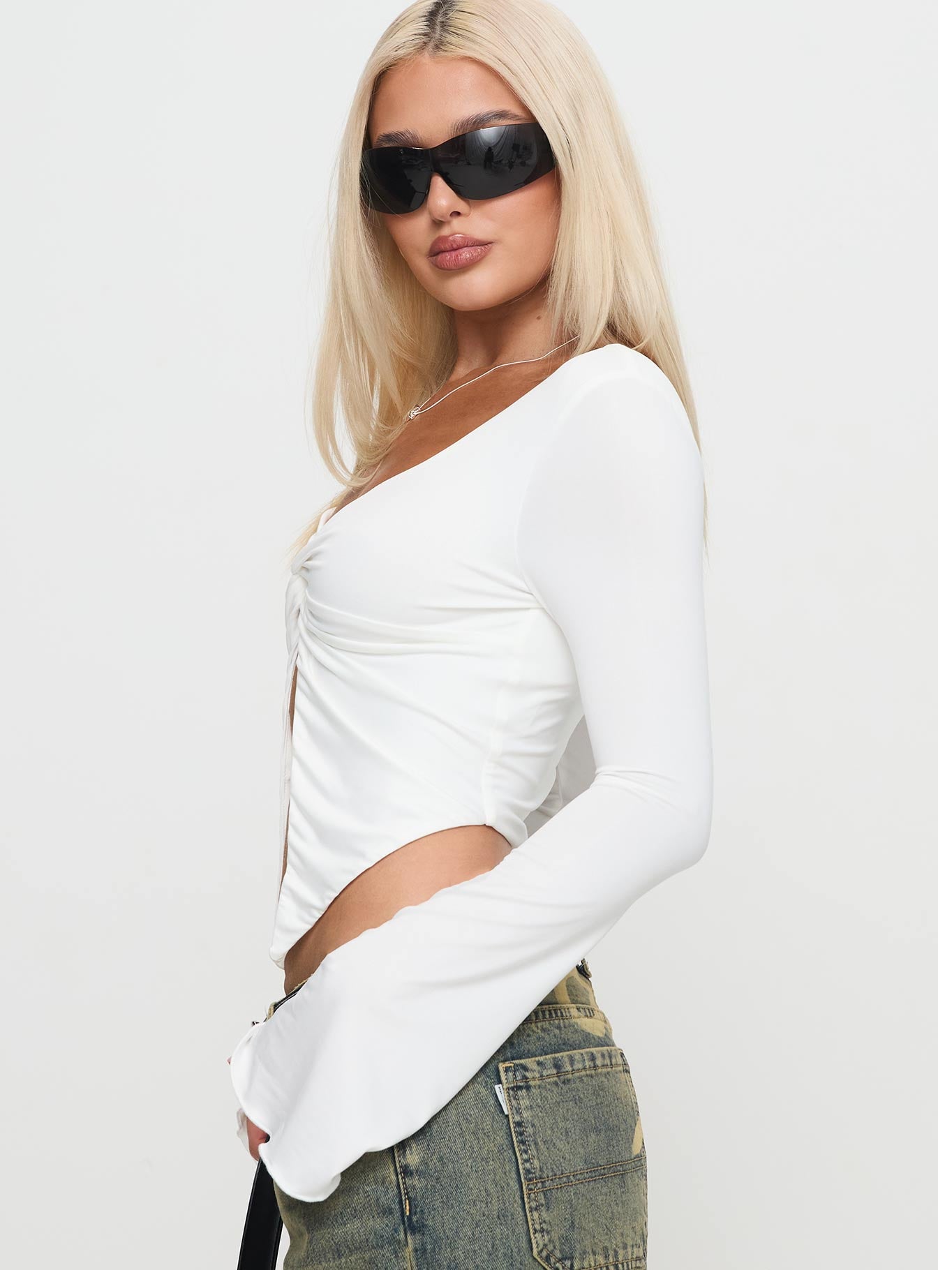 side view of model wearing Princess Polly Holli Long Sleeve Twist Top White Full Sleeves Plunger 
