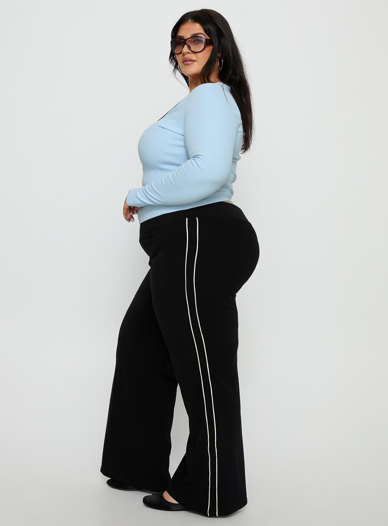 side view of model wearing Princess Polly Ascenda Straight Leg Track Pant Black Curve Mid Rise Pants 