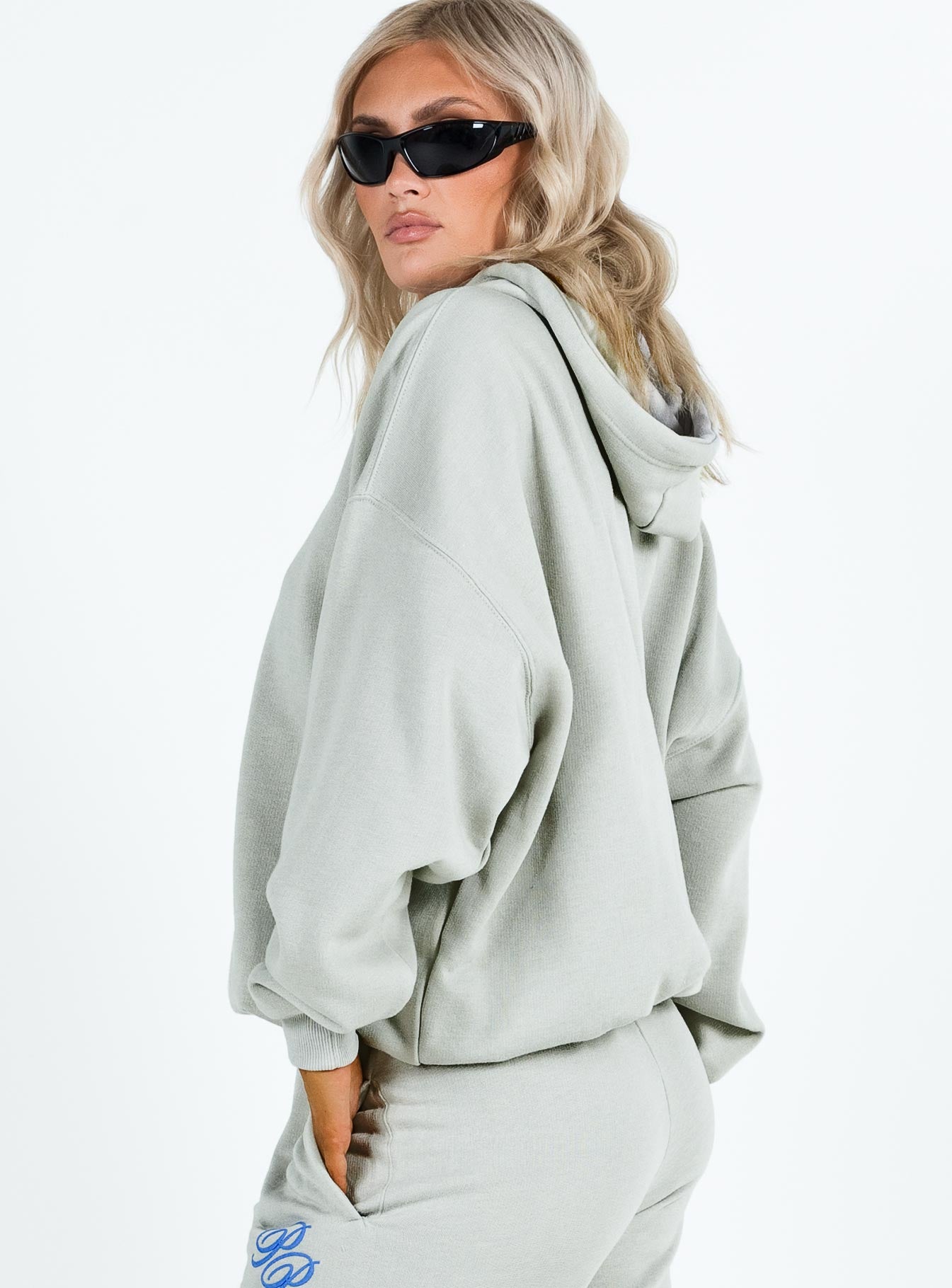 side view of model wearing Princess Polly Princess Polly Hooded Sweatshirt Cursive Text Grey / Blue regular 