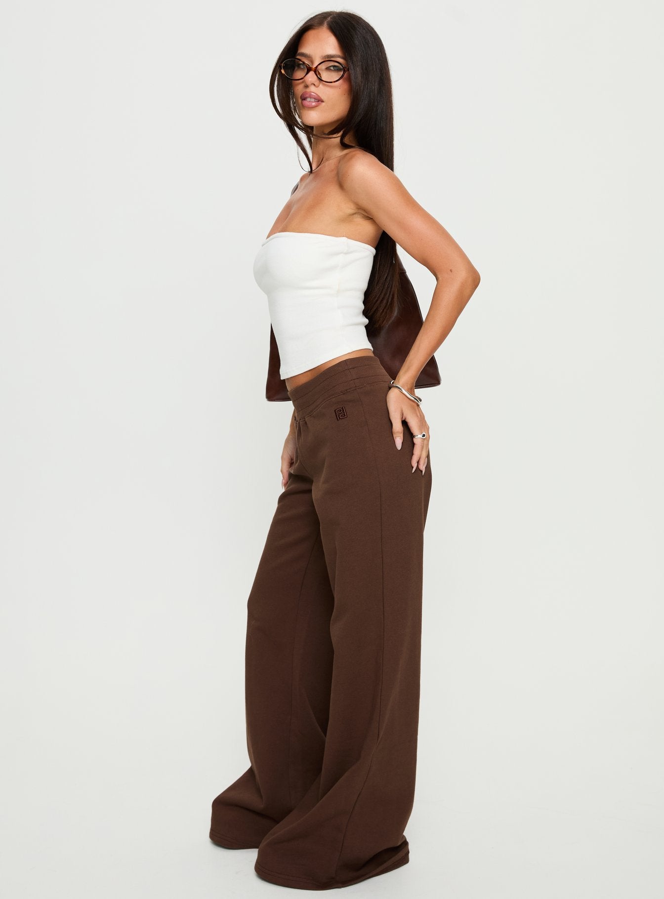 side view of model wearing Princess Polly Summits Flared Track Pants Chocolate High Rise Pants 