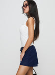 side view of model wearing Princess Polly There She Goes Skort Navy Low Rise Shorts 