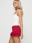 side view of model wearing Princess Polly Deei Double Ruffle Mini Skort Poppy Red Low Rise Shorts 