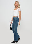 Front view of model wearing  front Princess Polly High Waisted  Thompson Low Rise Flared Jeans Mid Wash