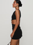 side view of model wearing Princess Polly Hardward Mini Dress Black Asymmetric Neckline 