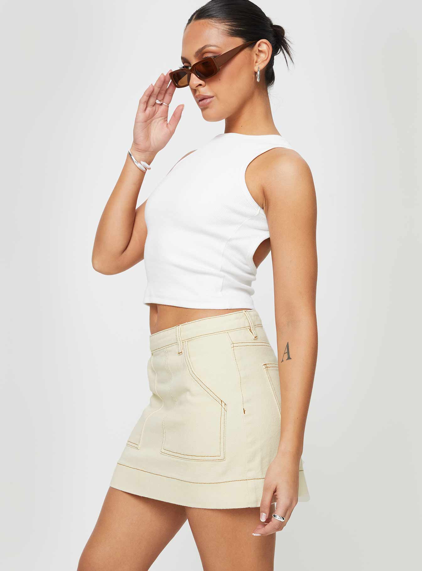  side view of model wearing Princess Polly Hughes Mini Skirt Cream Denim Mini Skirts 