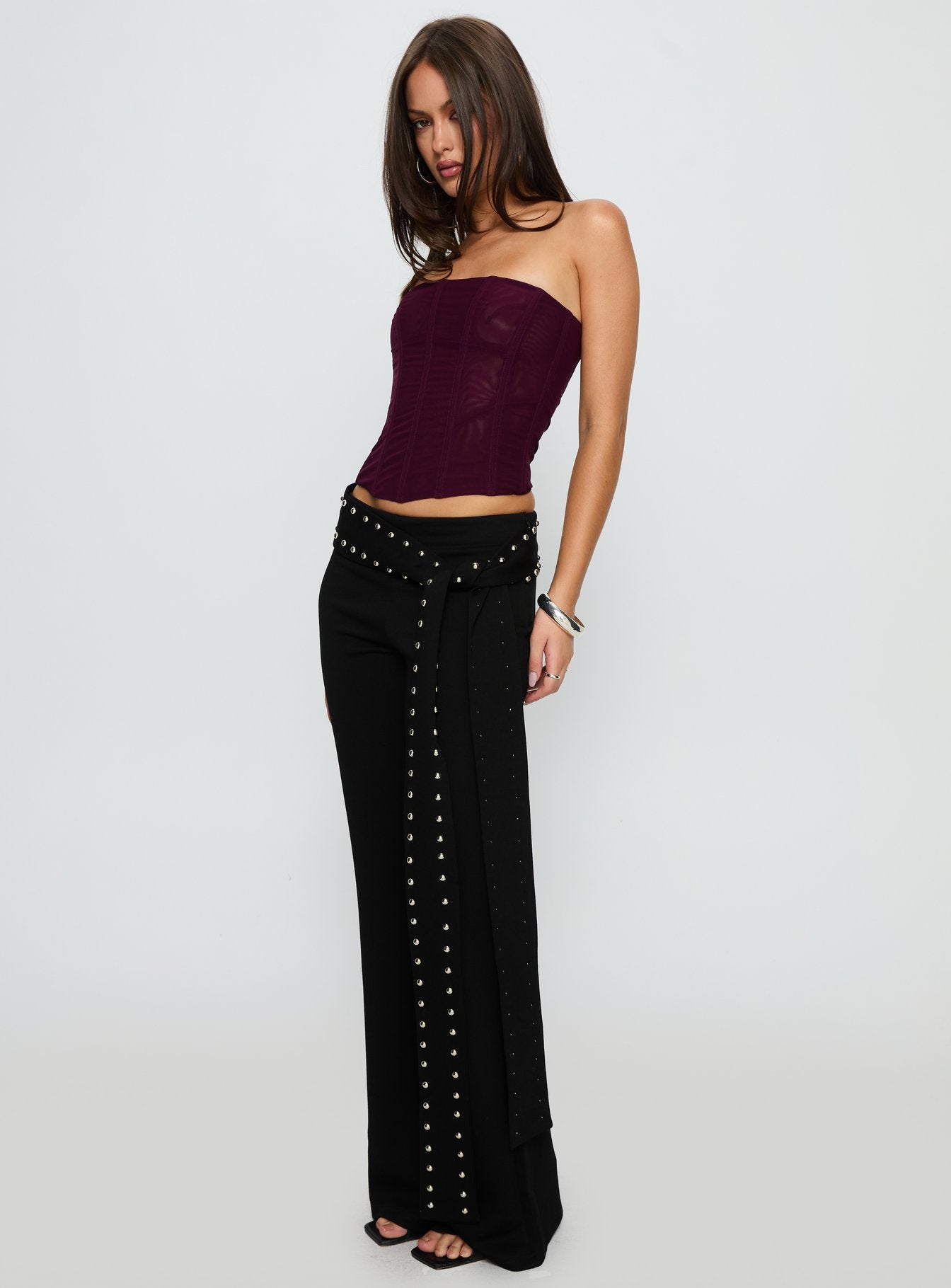 side view of model wearing Princess Polly Nikolia Studded Wrap Belt Pants Black Mid Rise Pants 