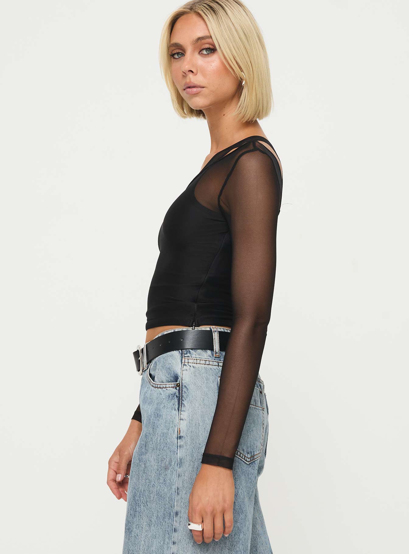 side view of model wearing Princess Polly Fulfilled Long Sleeve Top Black Full Sleeves Asymmetric Neckline 