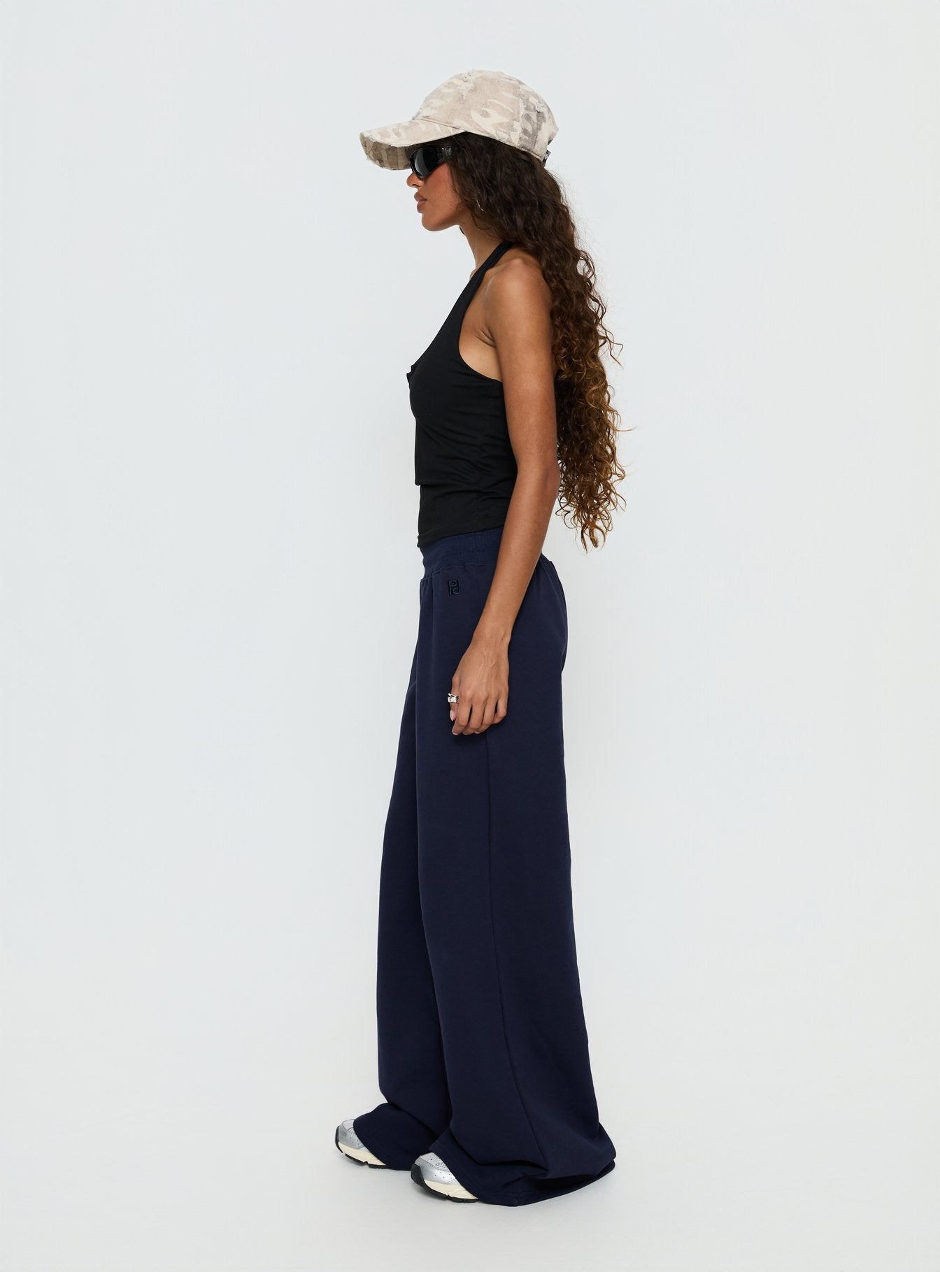 side view of model wearing Princess Polly Summits Flared Track Pants Navy Mid Rise Pants 