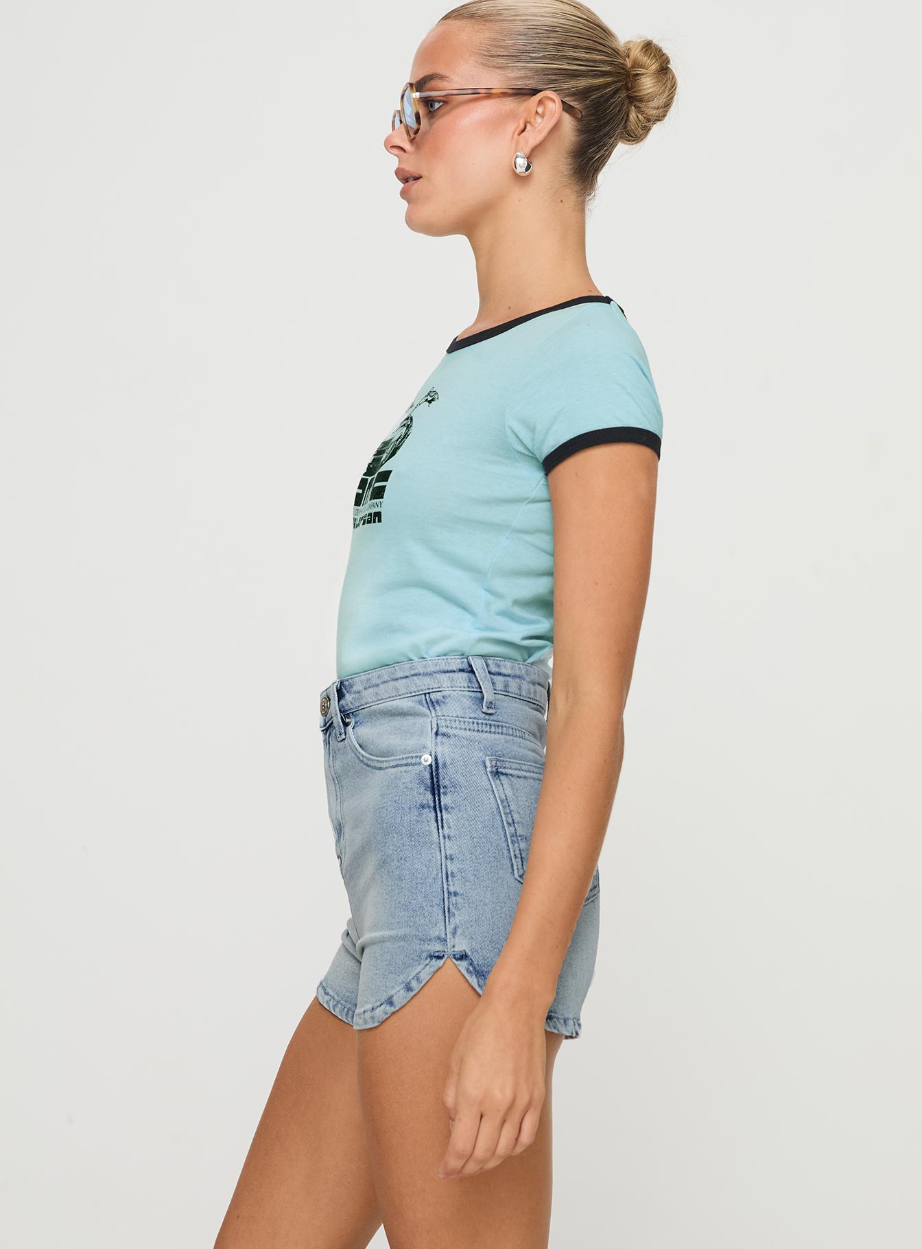 side view of model wearing Princess Polly Richardsons Denim Shorts Light Blue Wash High Waisted Shorts 