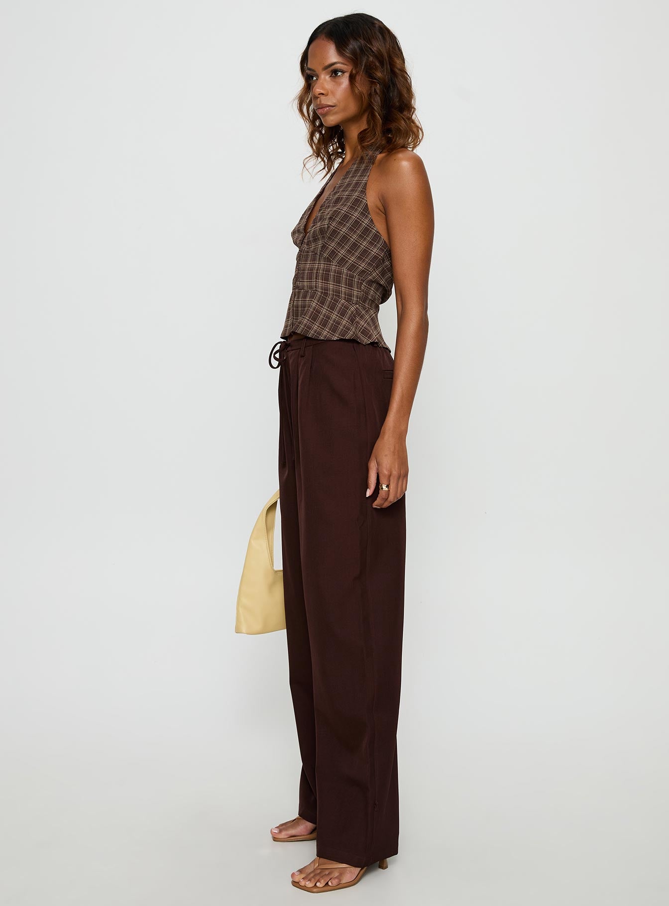side view of model wearing Princess Polly Idolised Pleated Tie Waist Pant Chocolate Brown Mid Rise Pants 
