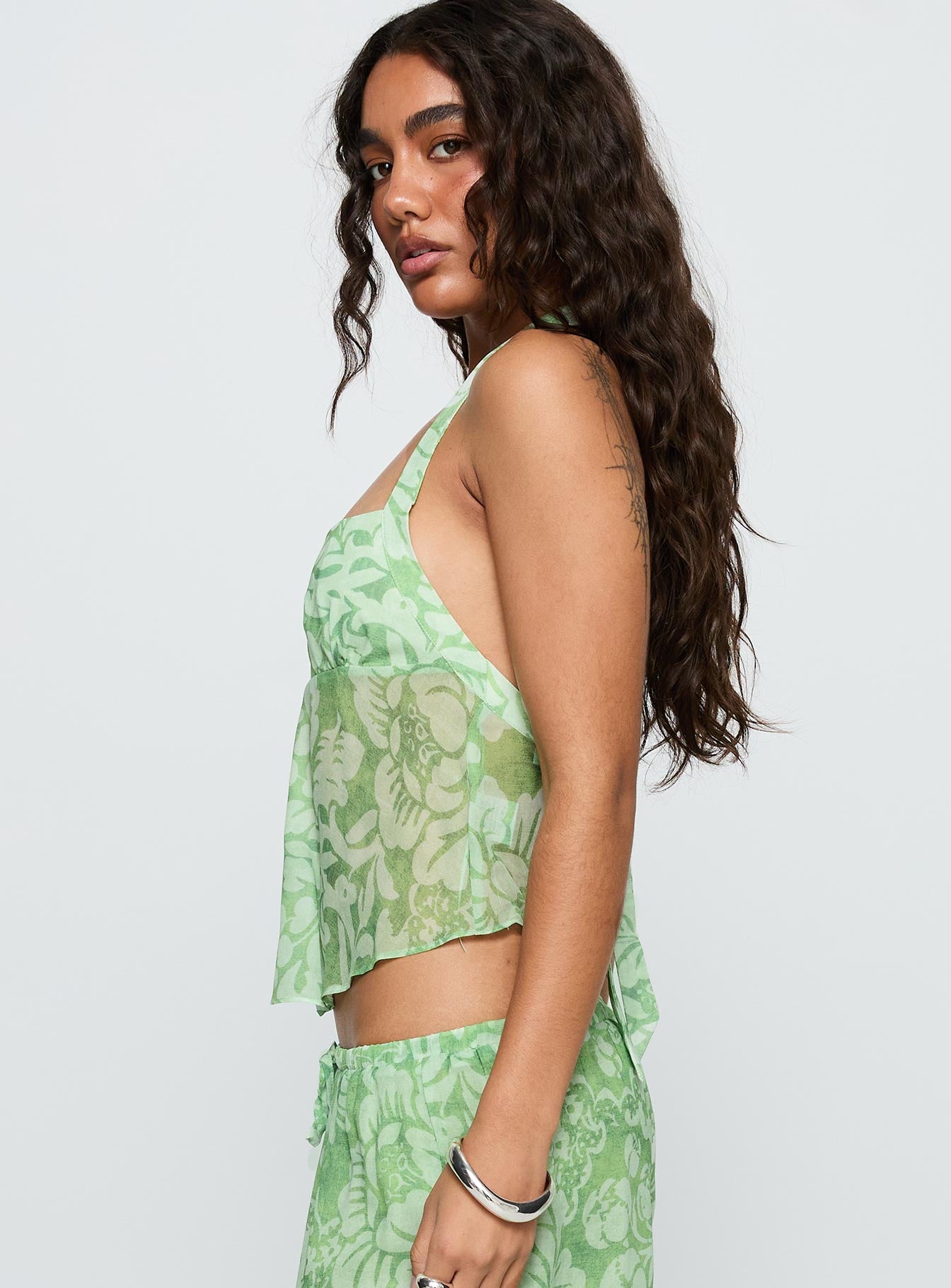 side view of model wearing Princess Polly Finesse Halter Top Green Floral Sleeveless Square Neck 