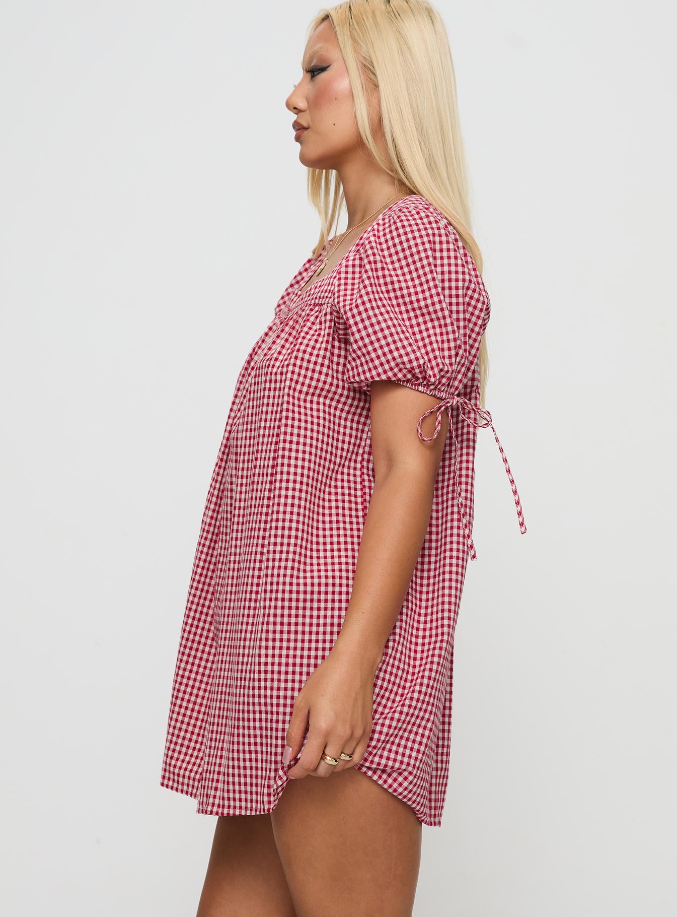 side view of model wearing Princess Polly Lilibet Mini Dress Red Gingham Square Neck 