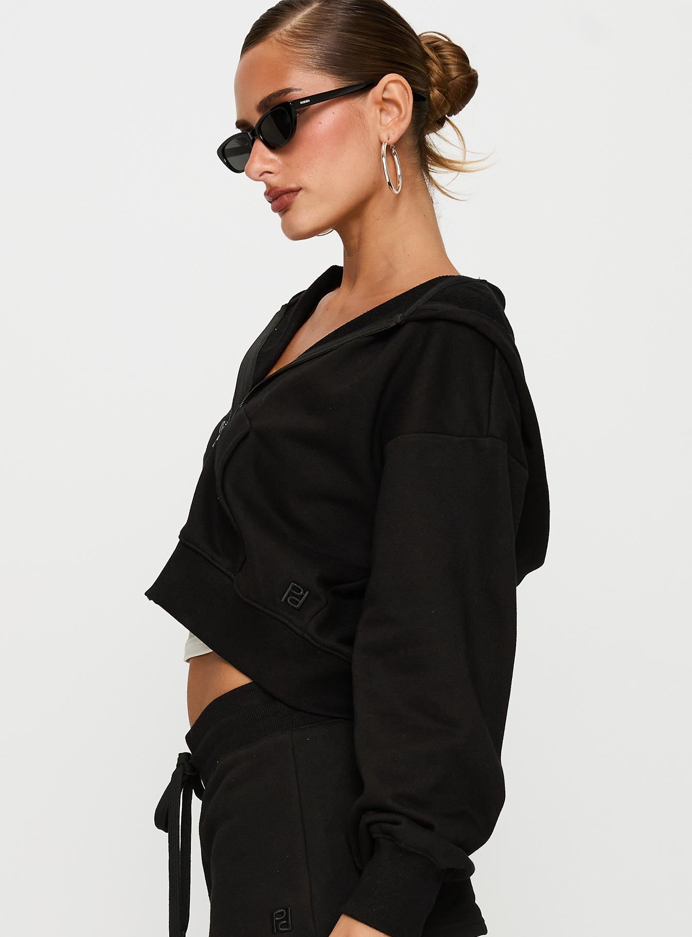 side view of model wearing Princess Polly Revive Zip Through Hoodie Black cropped 