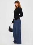 side view of model wearing Princess Polly Naylor Wide Leg Jeans Mid Blue Denim Petite Mid Rise 