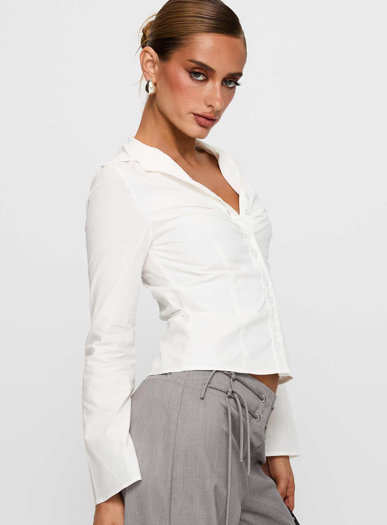 side view of model wearing Princess Polly Arianwyn Long Sleeve Shirt White Full Sleeves V-Neck 