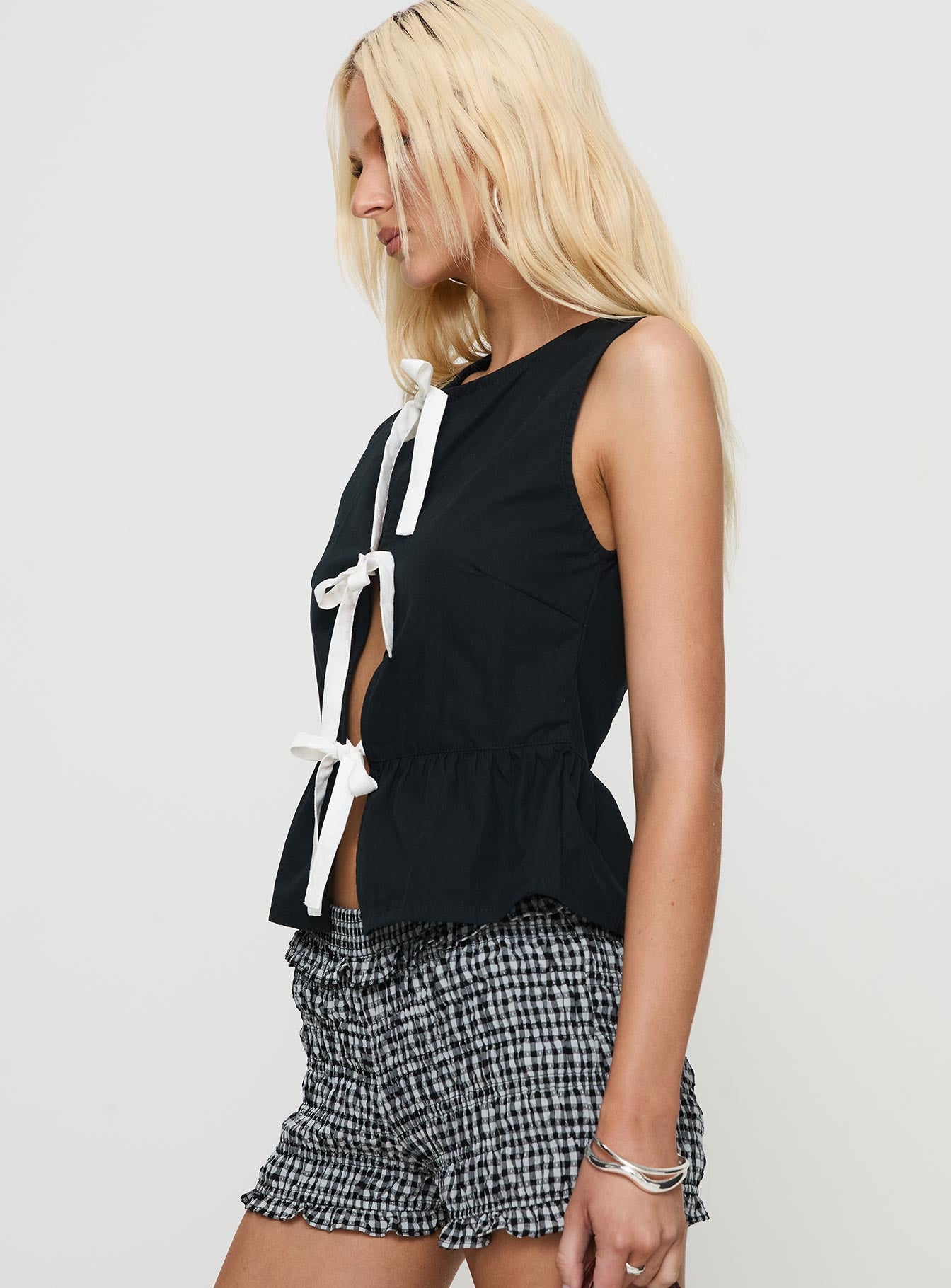 side view of model wearing Princess Polly Ryoti Top Black Sleeveless Crew Neck 