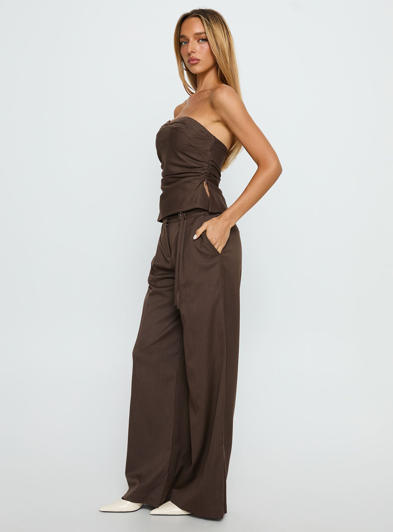 side view of model wearing Princess Polly Natilee Relaxed Tailored Pants Brown Pinstripe Low Rise Pants 
