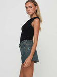 side view of model wearing Princess Polly Get It Right Mid Rise Denim Shorts Dark Denim Wash mid-rise 