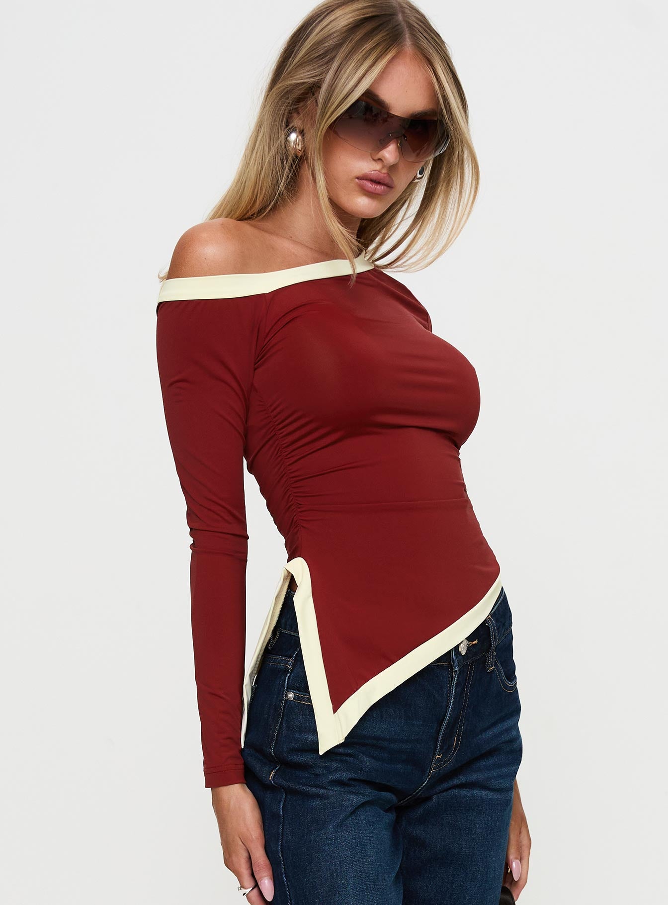 side view of model wearing Princess Polly Fake Smile Long Sleeve Top Burgundy / Cream Full Sleeves Asymmetric Neckline 