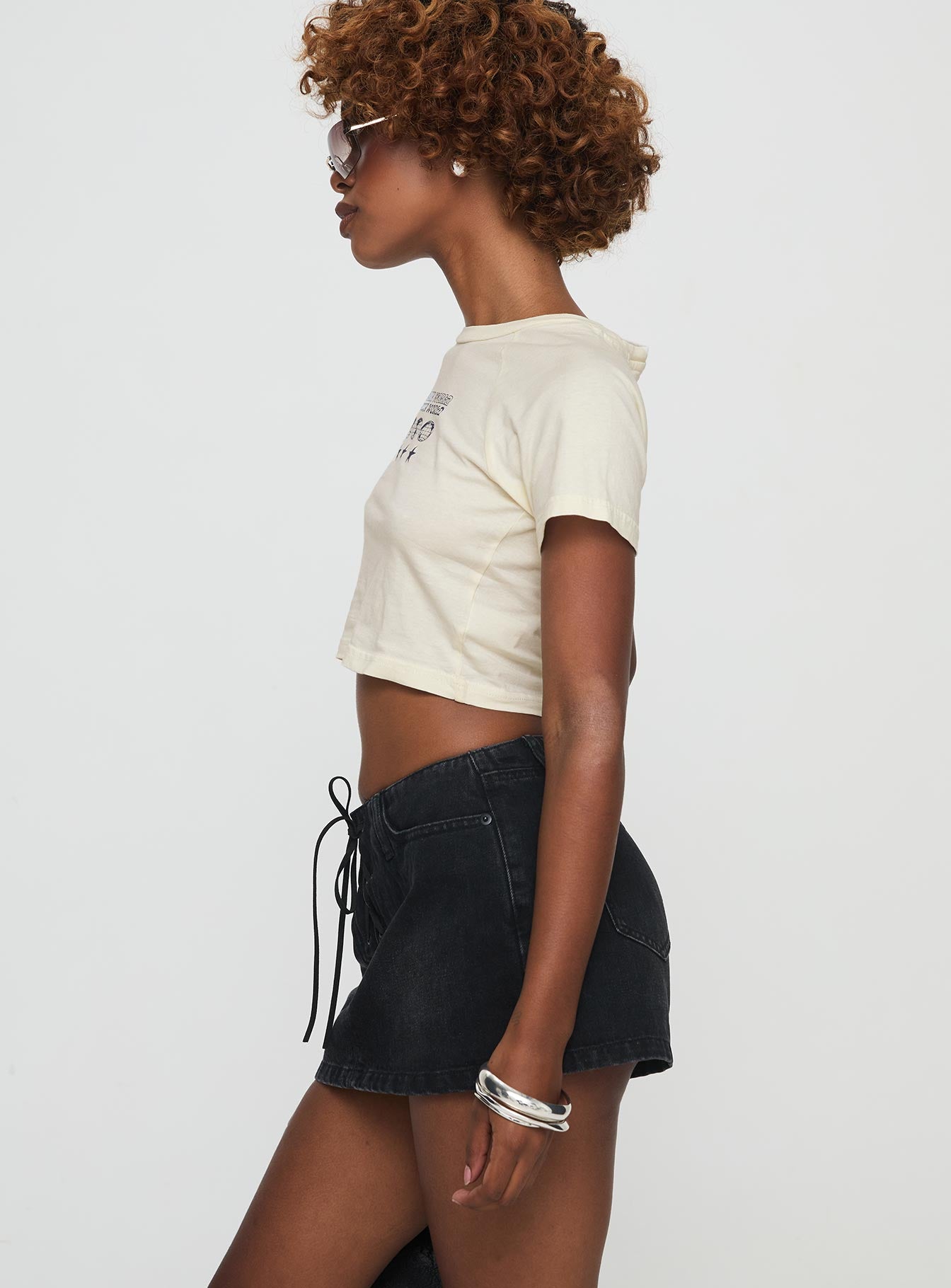 side view of model wearing Princess Polly Amethysta Denim Skort Black Low Rise Shorts 