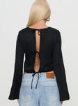 back view of model wearing Princess Polly Rhydian Long Sleeve Tie Top Black Full Sleeves Crew Neck 