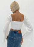 White long sleeve top Square neckline Balloon style sleeves Hook and eye fastening at front Lace trim Split hem Bell sleeves