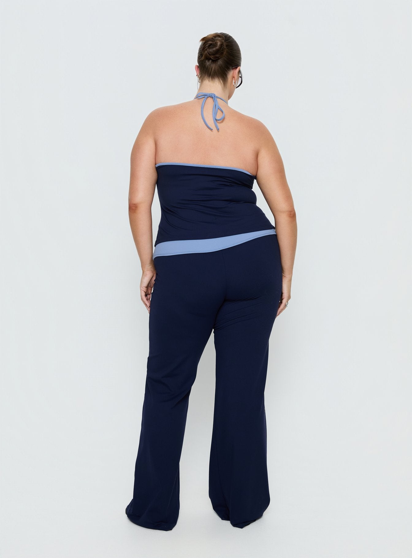 back view of model wearing Princess Polly Kobee Jersey Flare Pants Navy / Light Blue Curve High Rise Pants 