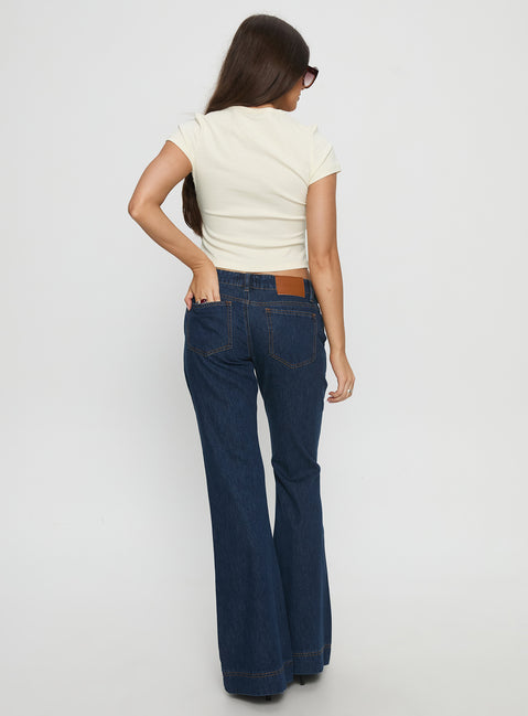 back view of model wearing Princess Polly Acapulco Low Rise Flare Jeans Dark Blue Wash Low Rise Jeans 